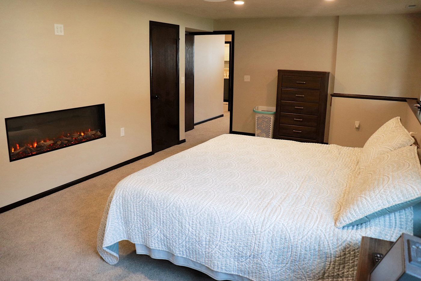 Finished basement bedroom with built-in electric fireplace